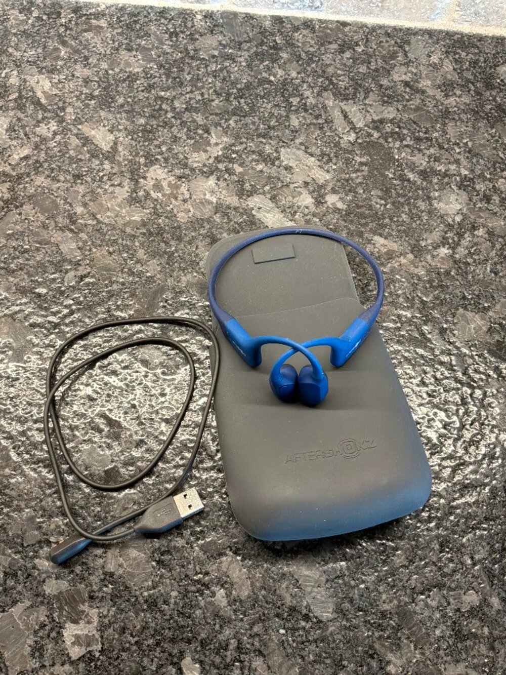 AfterShokz Aeroplex Bone Conduction Headphones with case and Charging cord.